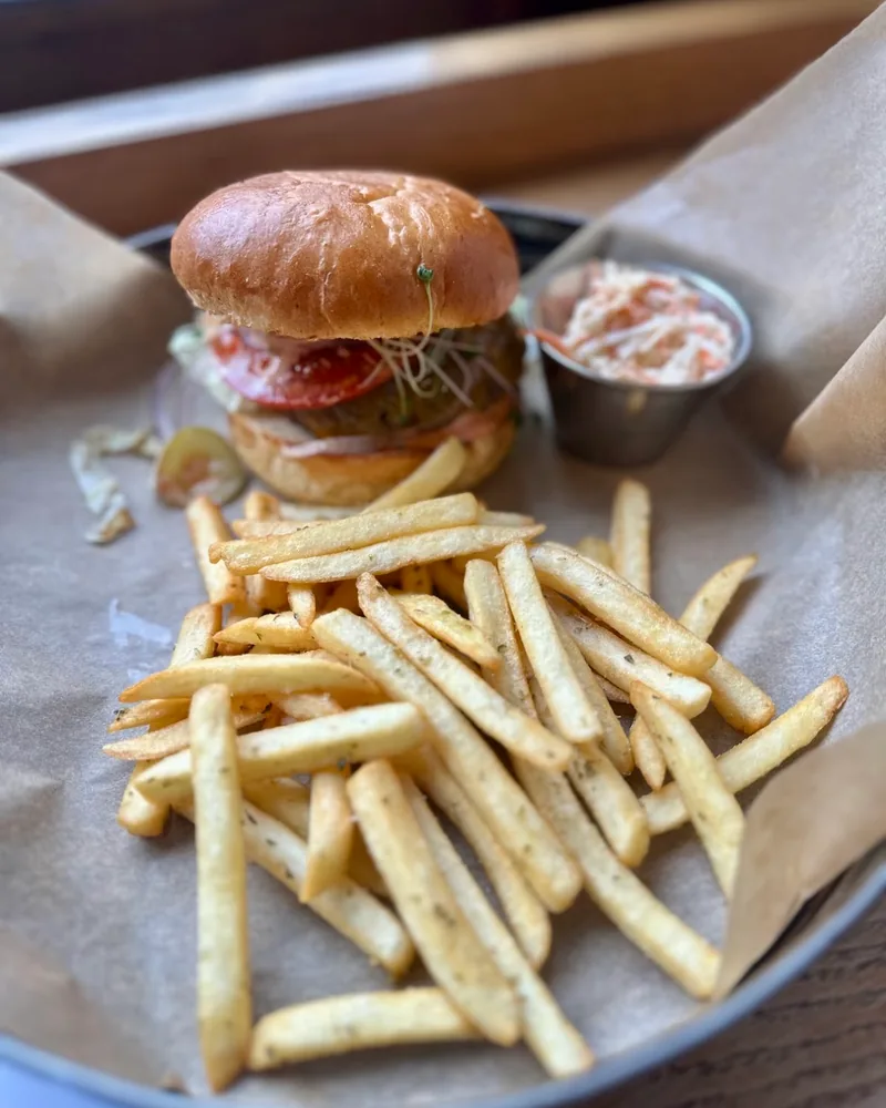 Burger and French fries with coleslaw in a metal tray at Burger House