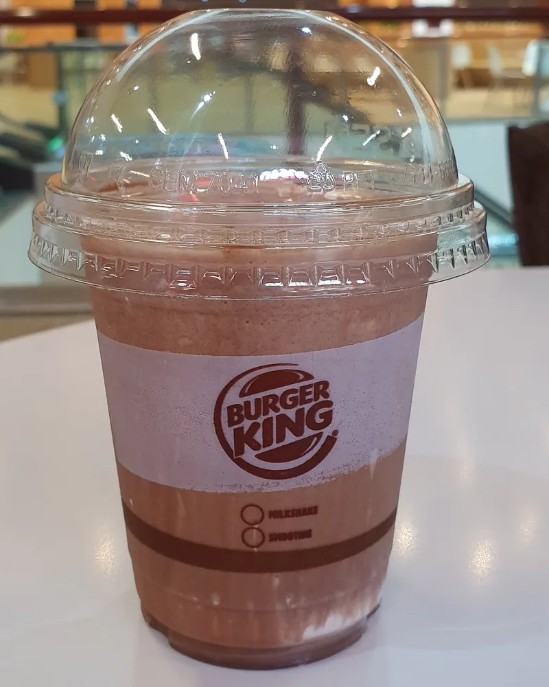 Chocolate milkshake in a plastic cup with a dome lid at Burger King