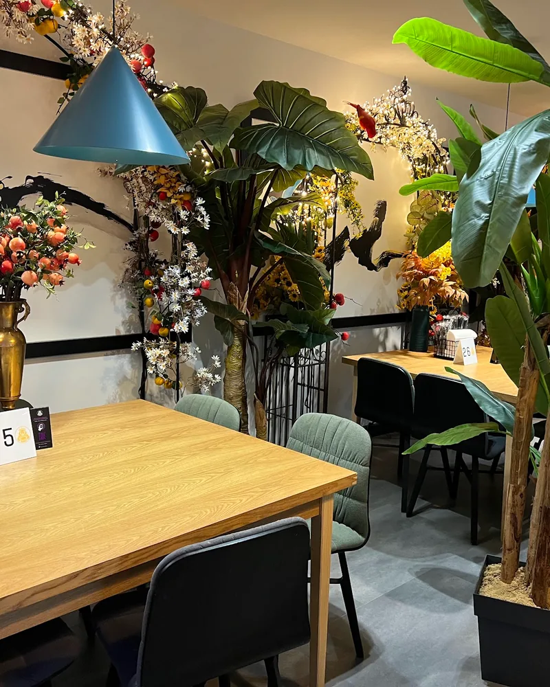 Dining area with plants and wooden tables at Burger Lions