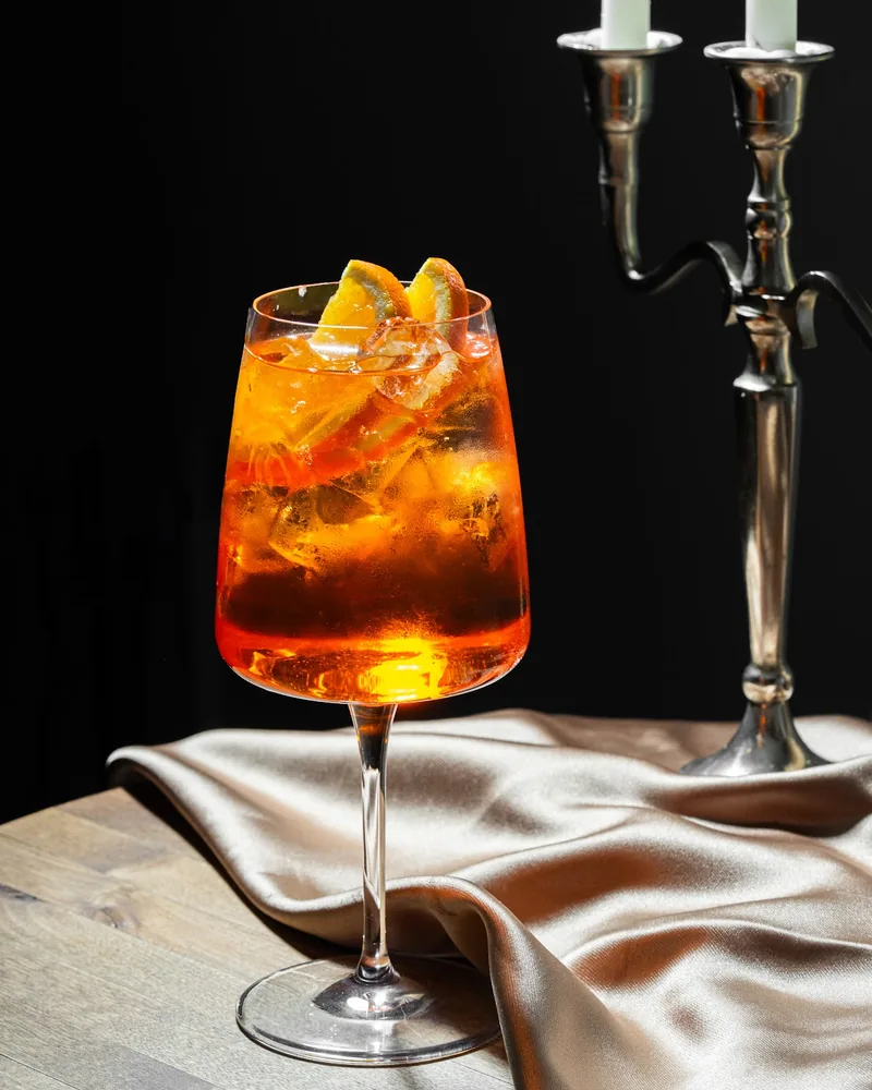 Spritz cocktail in a stemmed glass garnished with orange slices at Buro Bar