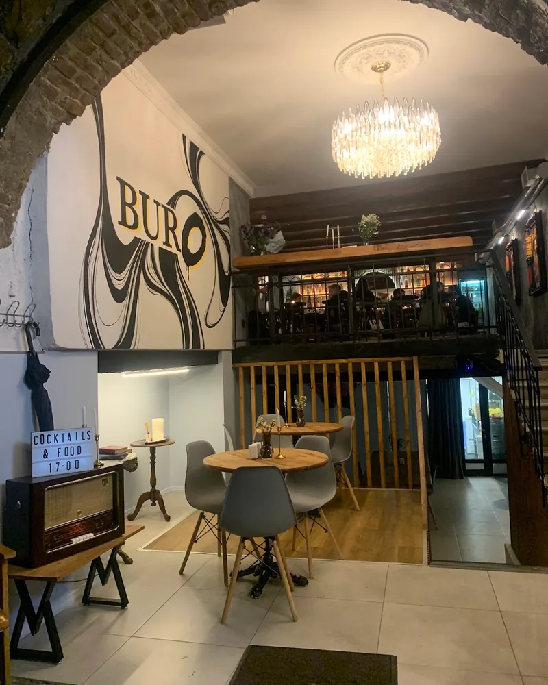 Two-level bar interior with brick arch and mural at Buro Bar