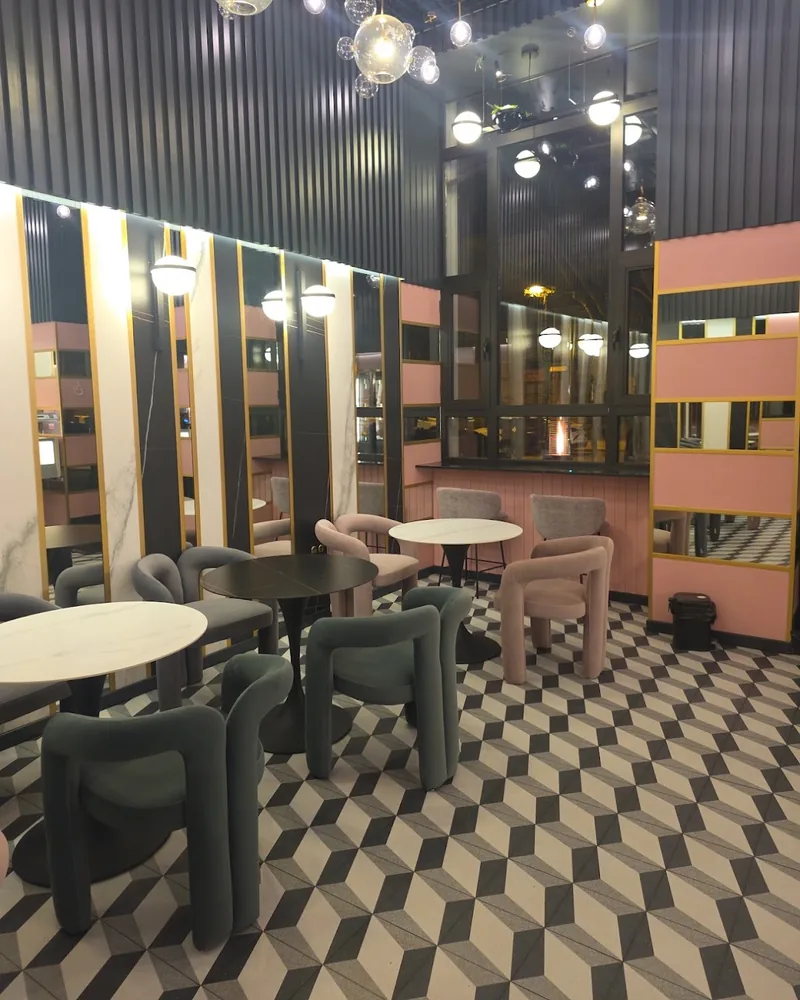 Dining area with geometric patterned floor and tubular chairs at Cafe 43