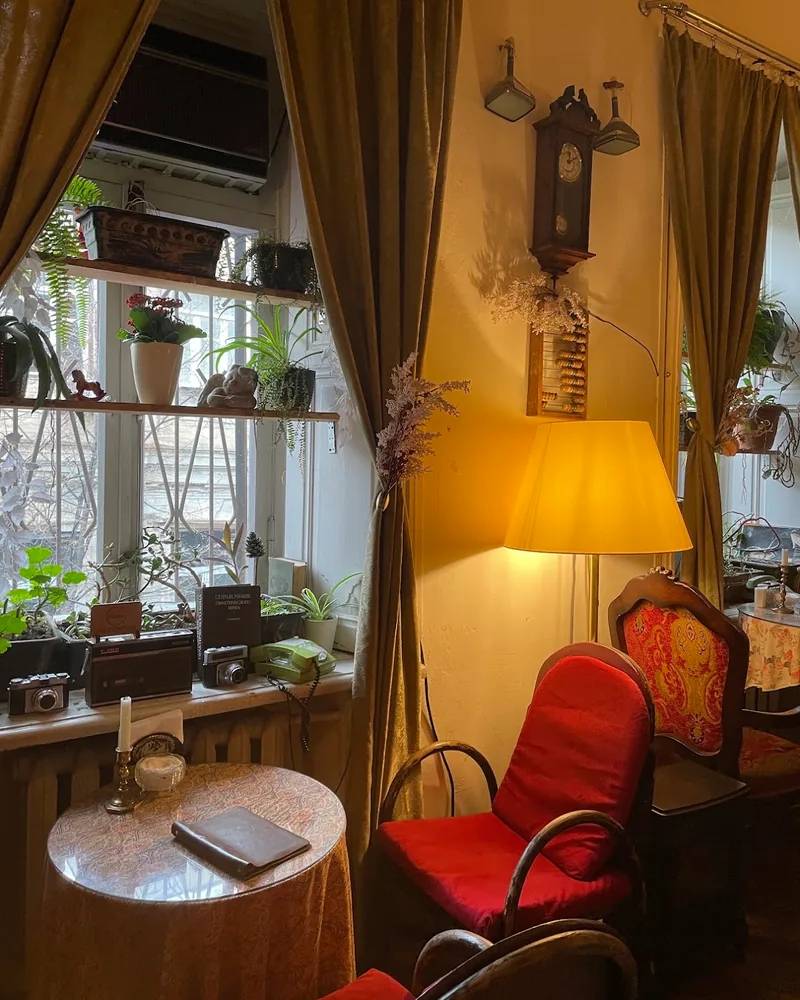 Vintage sitting corner by a window with a lamp and red armchairs at Cafe Dante