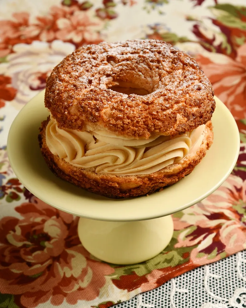 Paris-brest on a small yellow cake stand at Cafe Madeleine