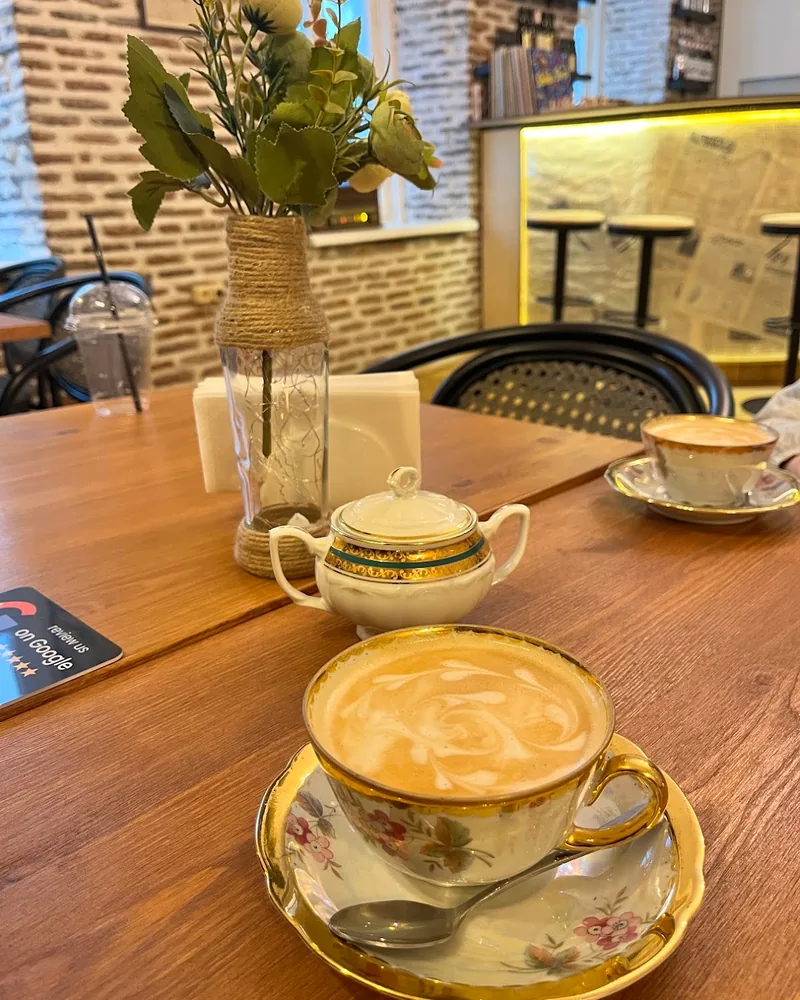 Latte in a vintage porcelain teacup with saucer at Cafe Mellow