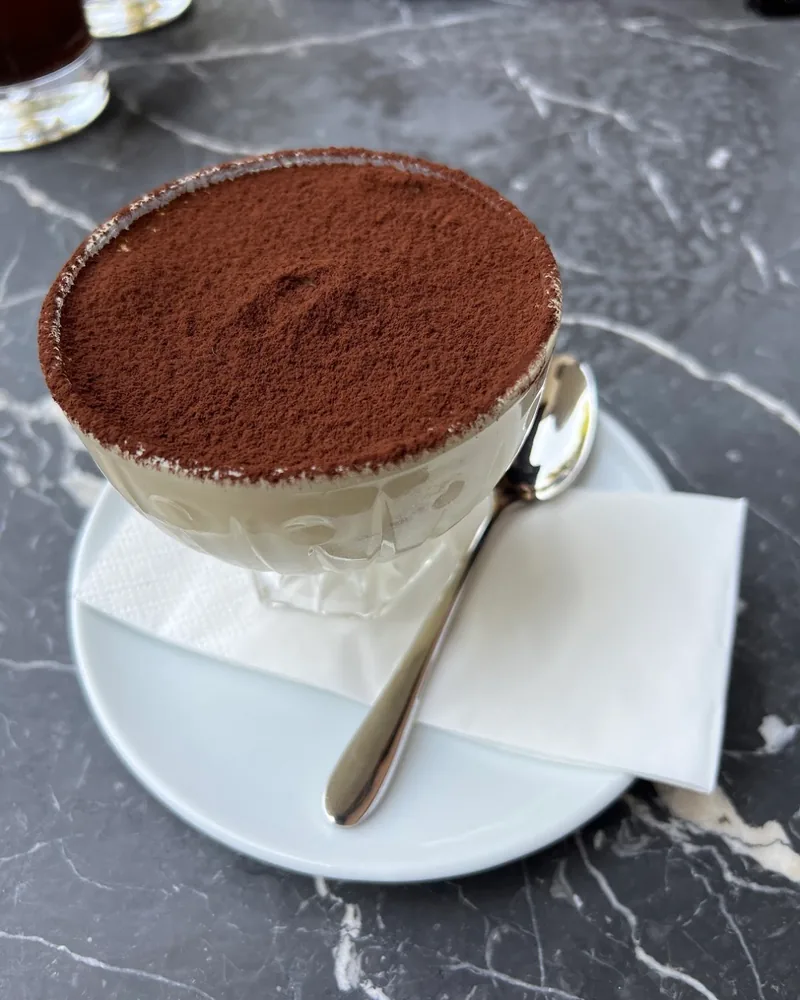 Tiramisu in a glass coupe on a saucer at Cafe Museum