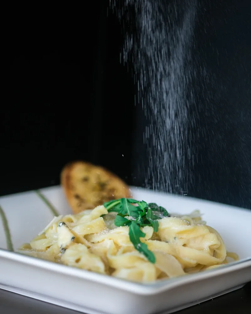 Fettuccine pasta with grated cheese being sprinkled over at Cafe Museum
