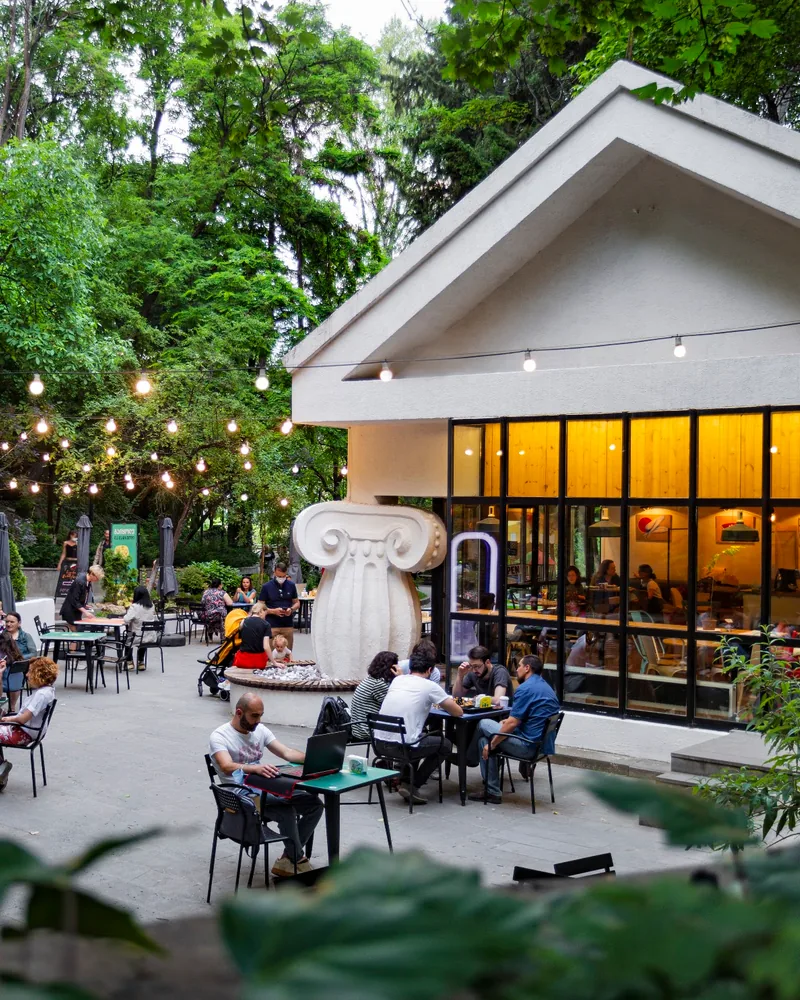 Outdoor courtyard seating beside park pavilion cafe at Cafe Mziuri