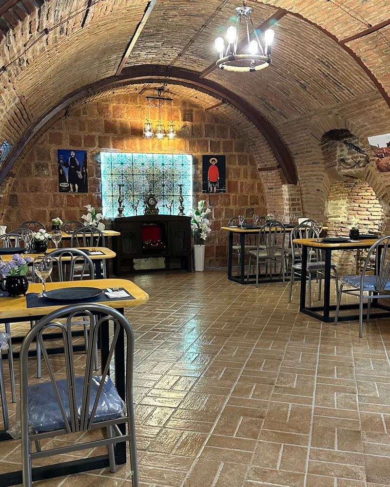 Vaulted brick dining room with wooden tables at Cafe Nice