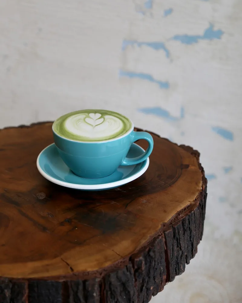 Matcha latte in a teal ceramic cup at Caffeine by WorkIn