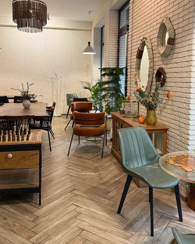 Cafe seating area with parquet flooring and brick wall at Caffeine by WorkIn