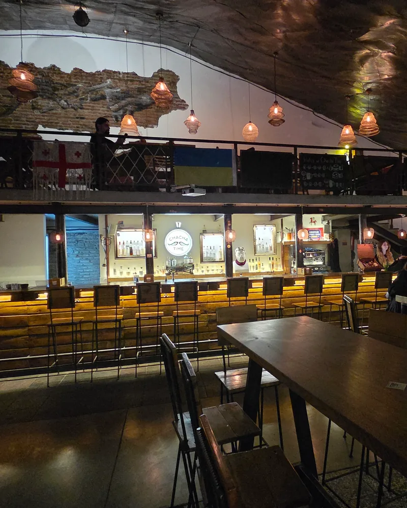 Two-level bar interior with a counter and mezzanine seating at Chacha Time