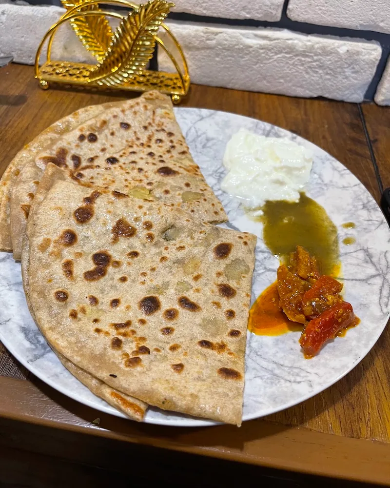 Stuffed parathas with yogurt, chutney and pickle at Chai GPT