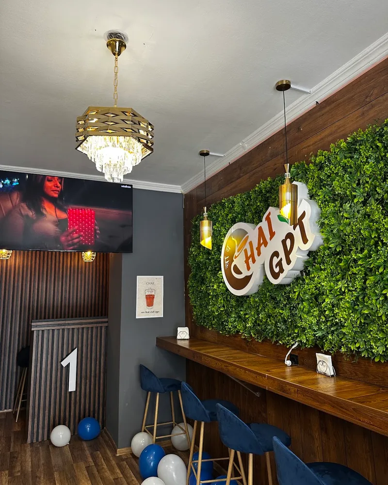Seating counter with green plant wall and logo at Chai GPT