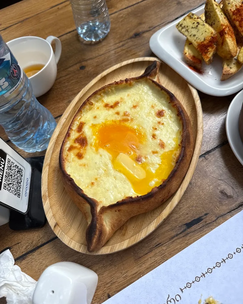 Adjarian khachapuri on an oval wooden plate at Chashnagiri