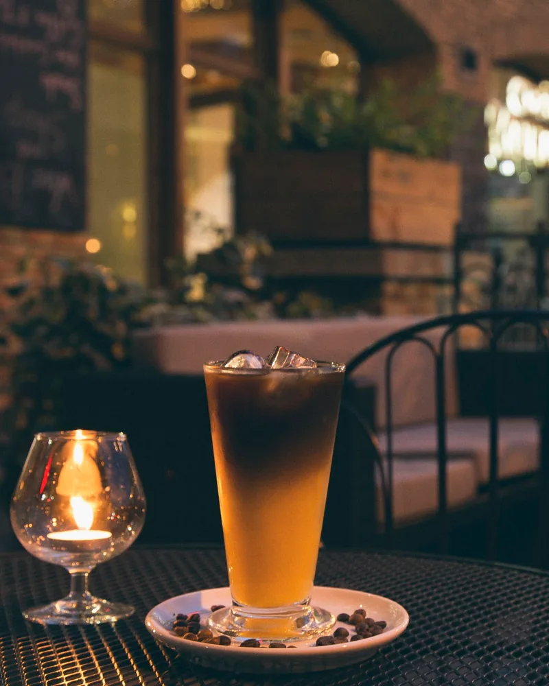 Layered iced coffee drink on a patio table at Château Mukhrani Wine Bar