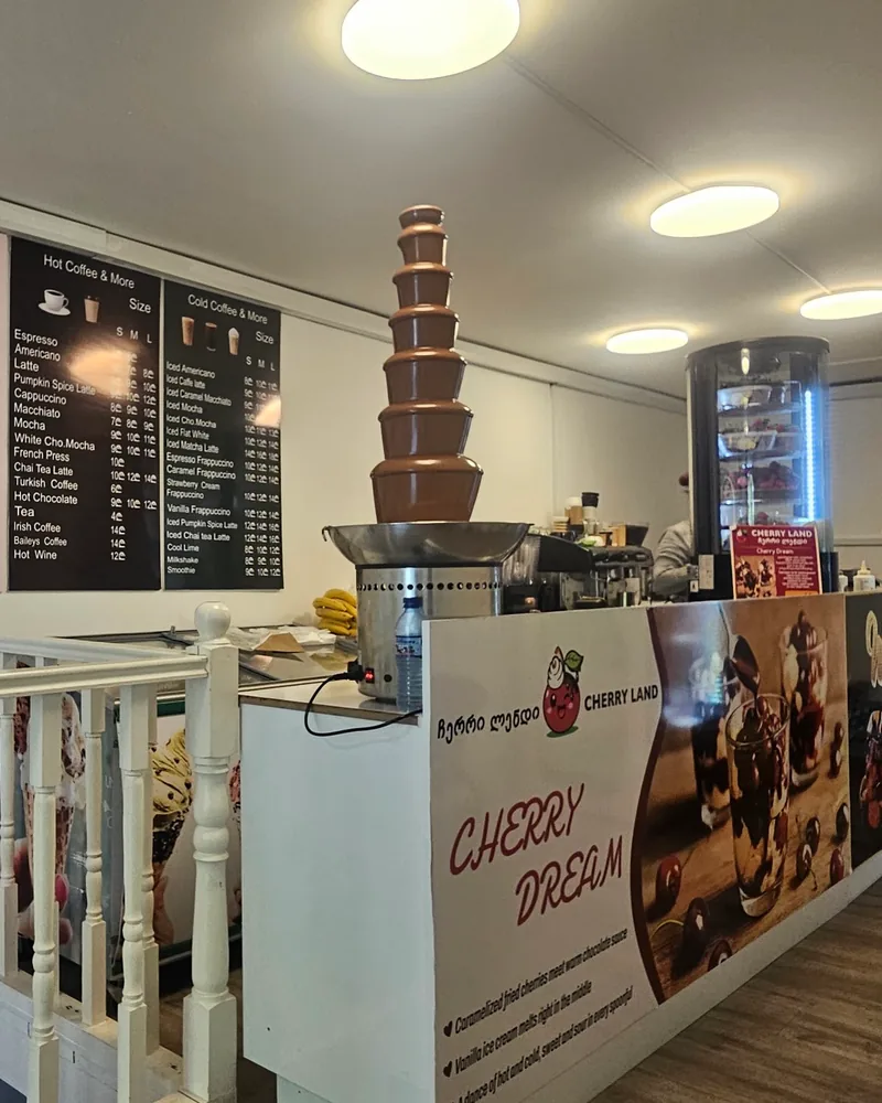 Counter with a chocolate fountain and menu boards at Cherry Land