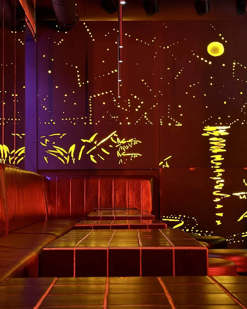 Seating booth and illuminated wall art at Cocktail Factory