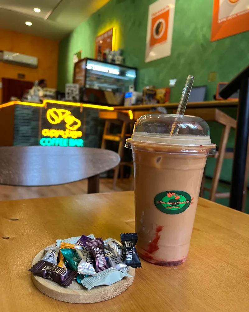 Iced coffee in a plastic takeaway cup with sweets at Coffee Bar