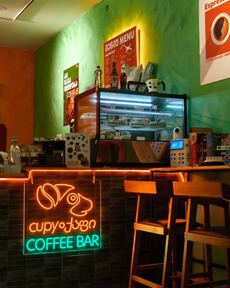 Coffee bar counter with neon sign and display case at Coffee Bar