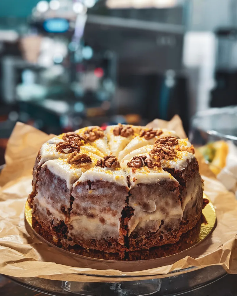 Whole walnut carrot cake on parchment paper at Coffee Place