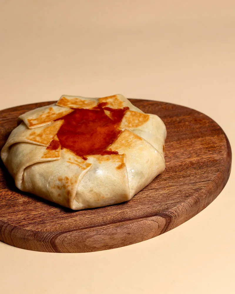 Wrapped pastry tart on a wooden board at Craft Food