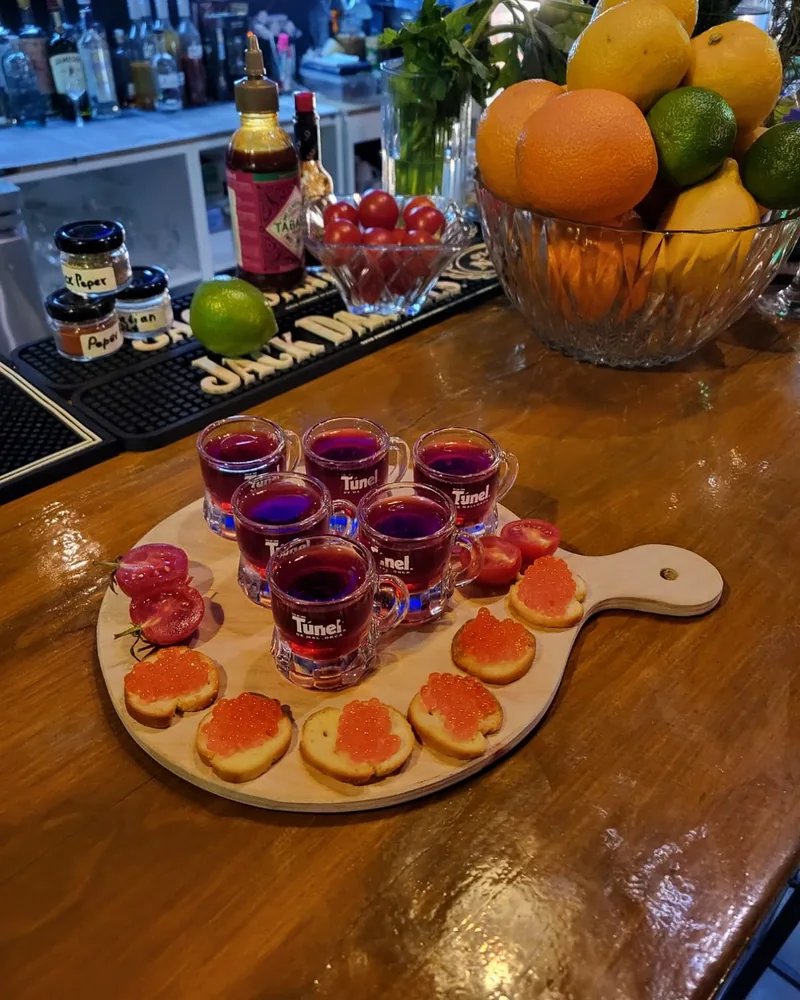Shot board with red shots and caviar canapés at D22 Bar