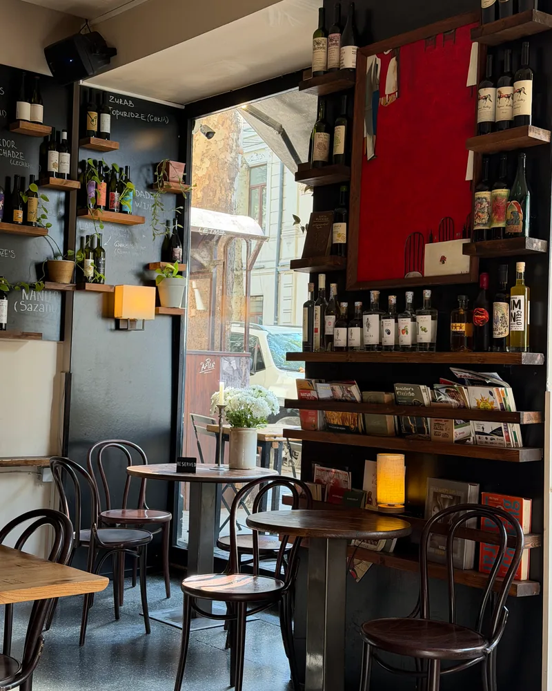 Wine bar interior with bottle shelves and wooden tables at DADI Wine Bar & Shop