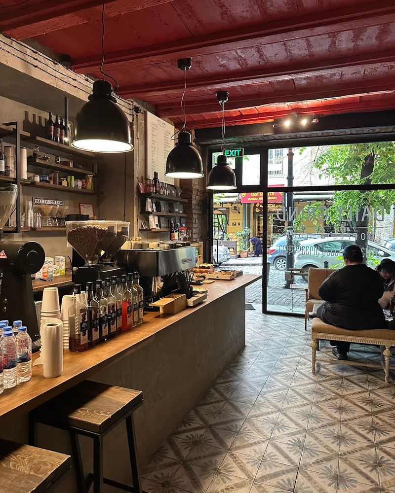 Coffee bar counter with espresso machine and red ceiling at Daily Grind