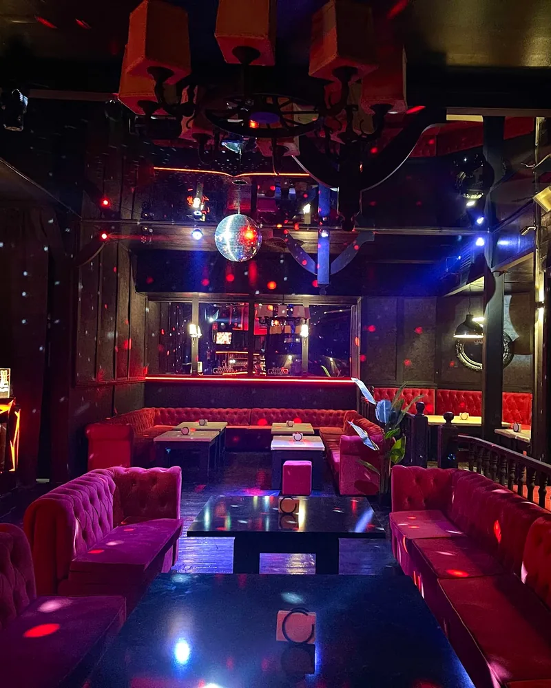 Pub lounge with red tufted booths and disco ball at Dallas Pub