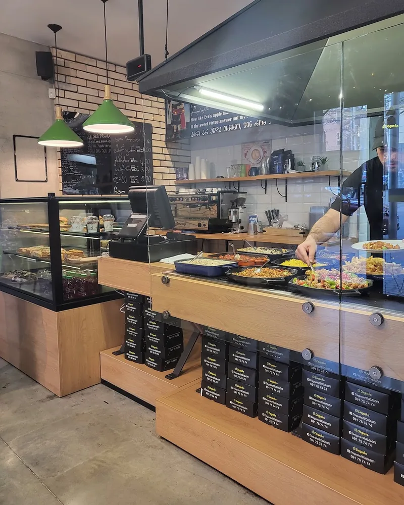 Service counter with hot food display and bakery cases at Degusto