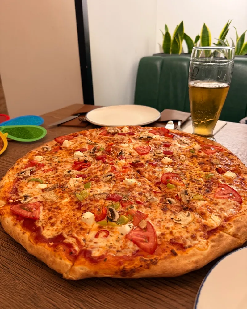 Whole pizza with mushrooms and tomatoes at Di Roma