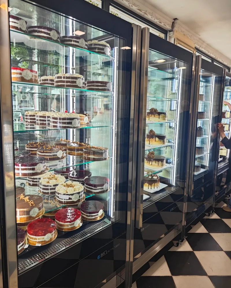 Refrigerated display cases filled with whole cakes at Dolce Vita