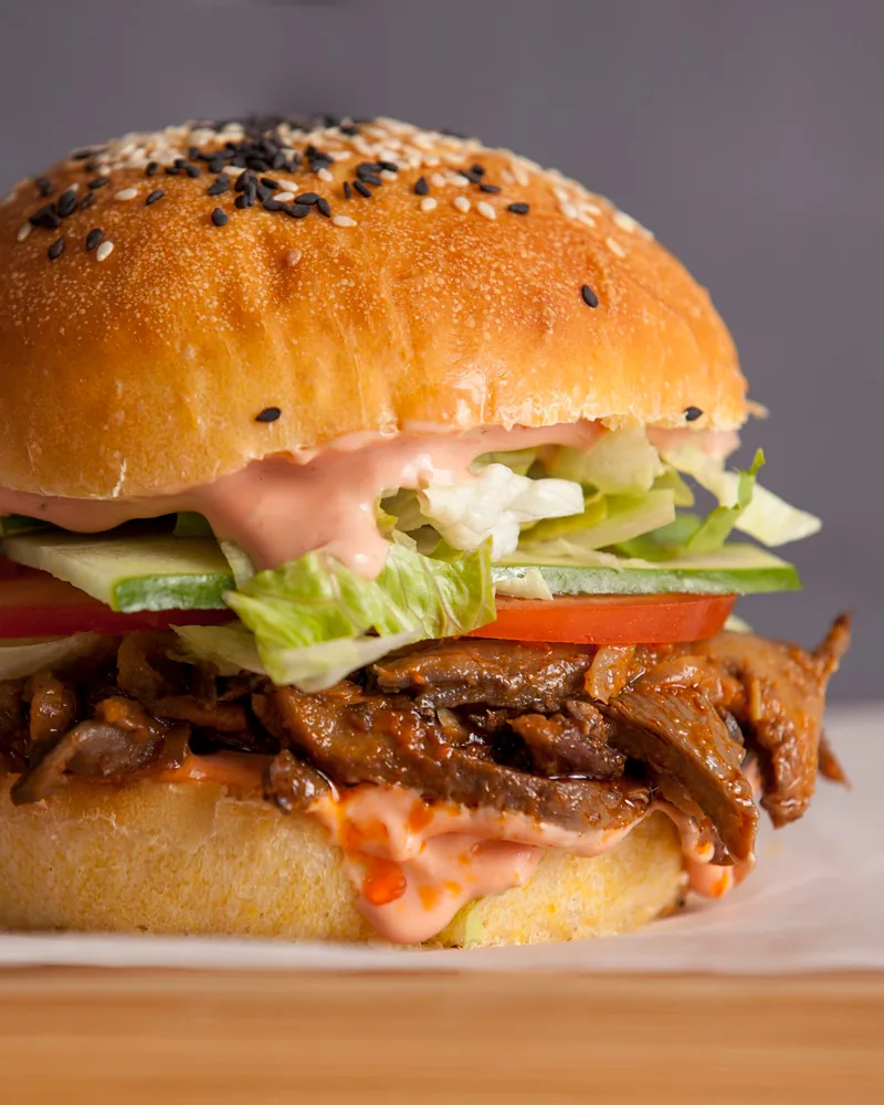 Plant-based burger with barbecue pulled filling, lettuce and tomato at Doomfara