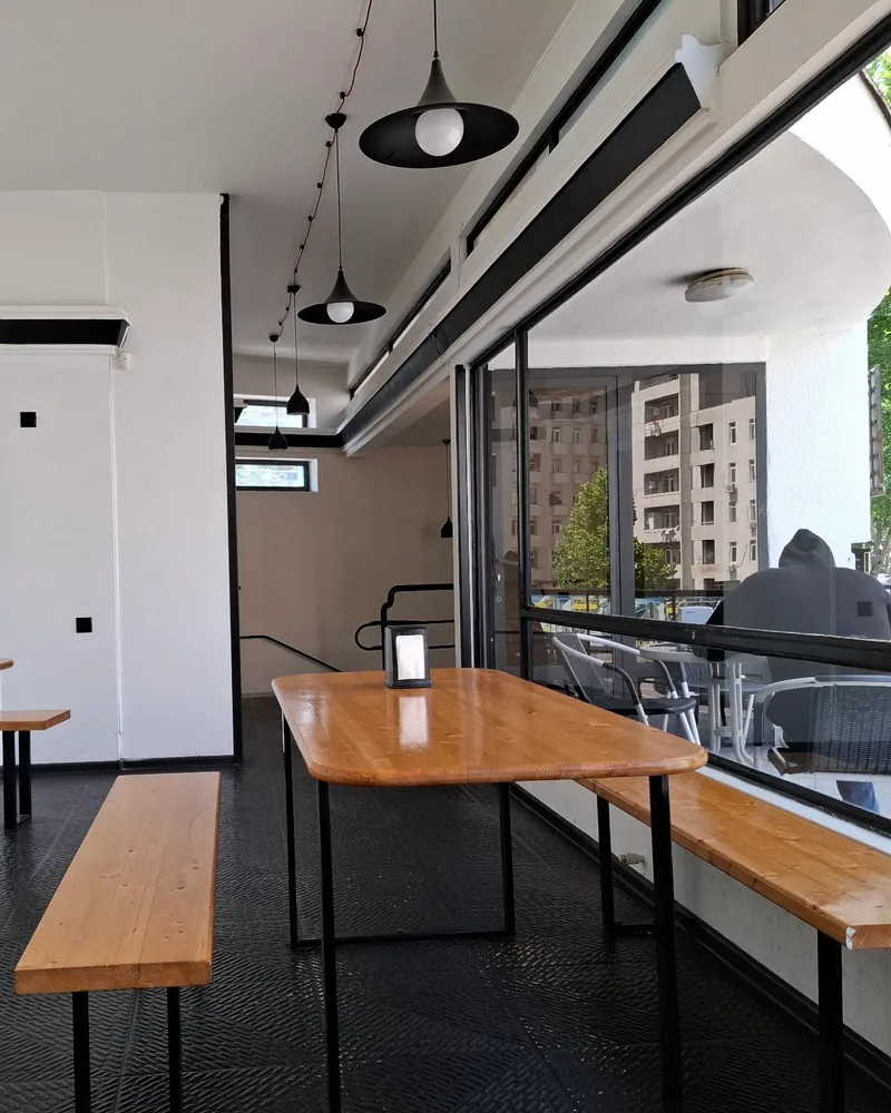 Indoor dining area with wooden benches and large windows at Fire Wok (Saburtalo)
