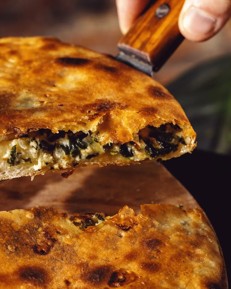 Slice of stuffed pie lifted with a spatula at Fragment