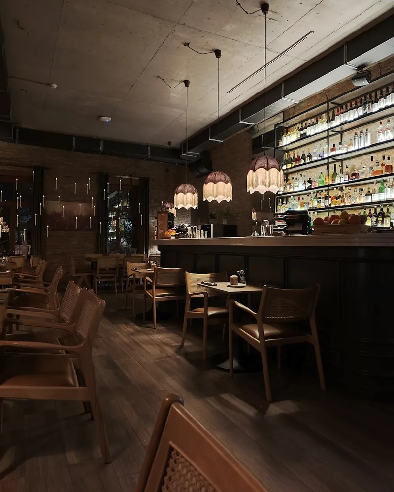 Dimly lit dining room with bar counter and pendant lamps at Fragment