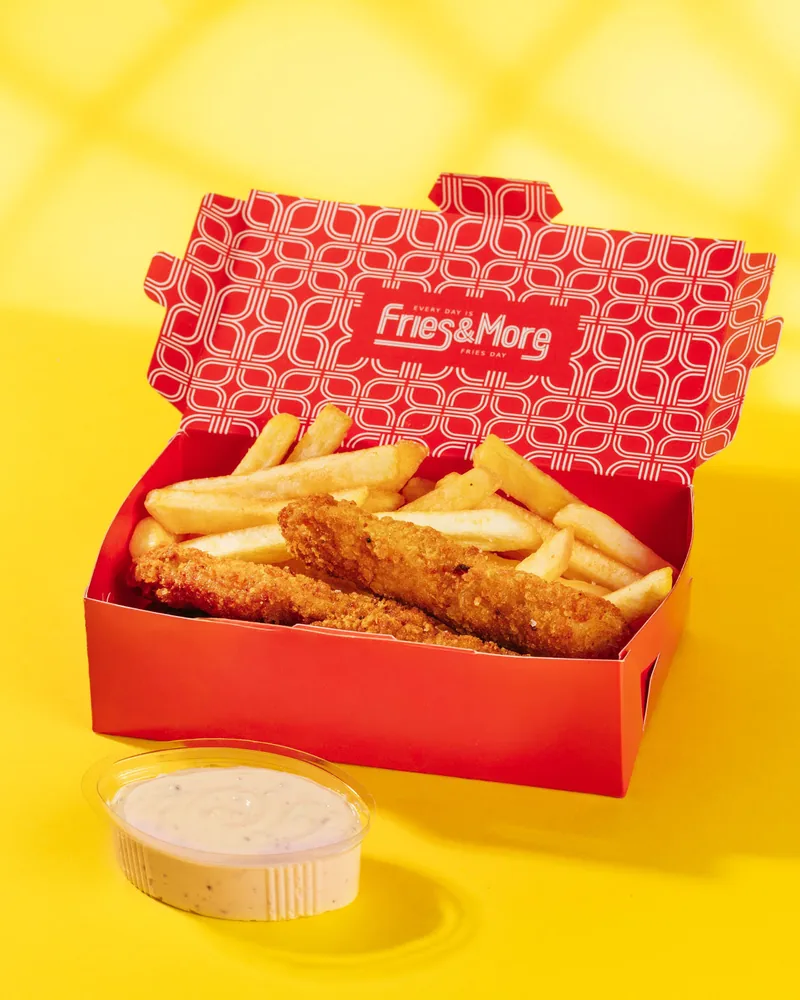 Chicken tenders and french fries in a red takeaway box with dipping sauce at Fries & More