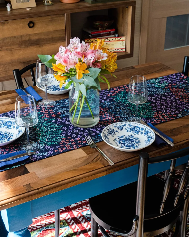 Set dining table with floral runner and vase at Georgian Flavors