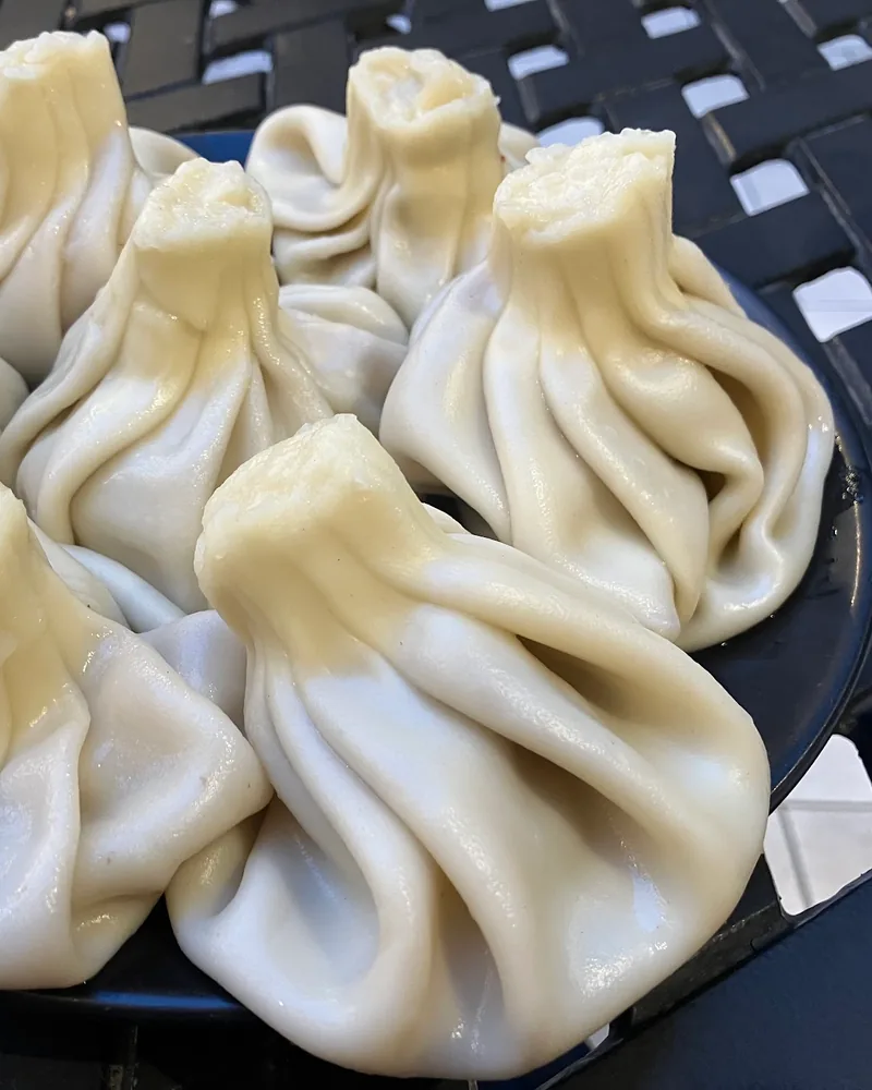 Khinkali dumplings on a black plate at Georgian House