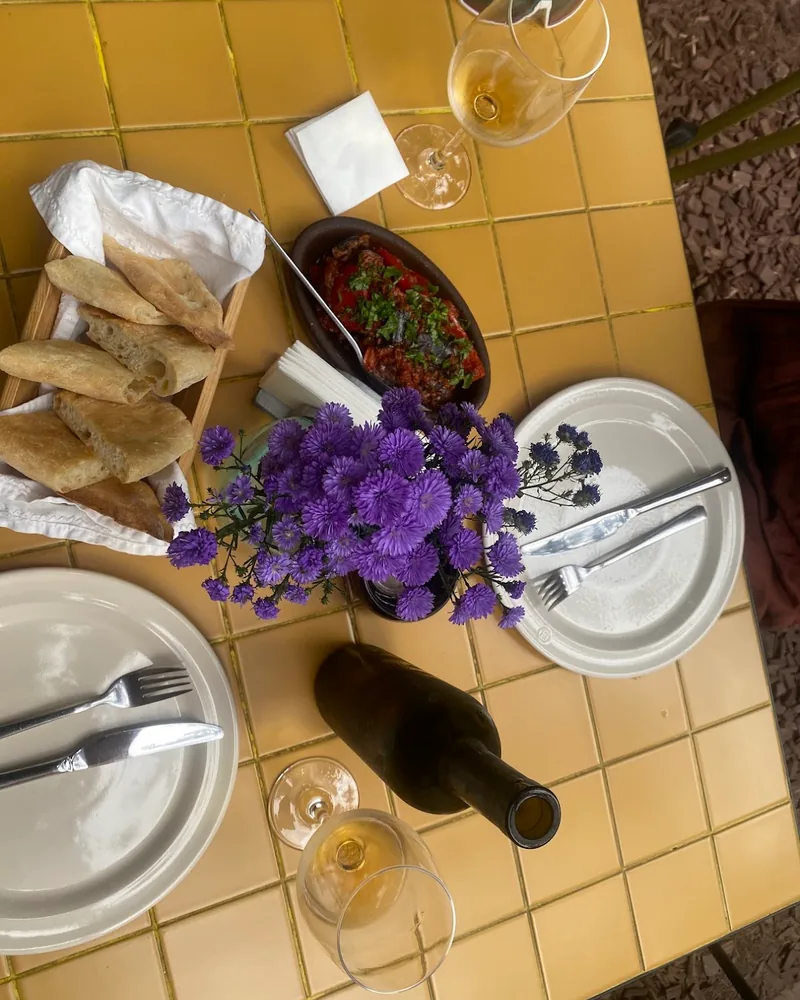Table spread with bread, dip, wine and flowers at Giorgobistve
