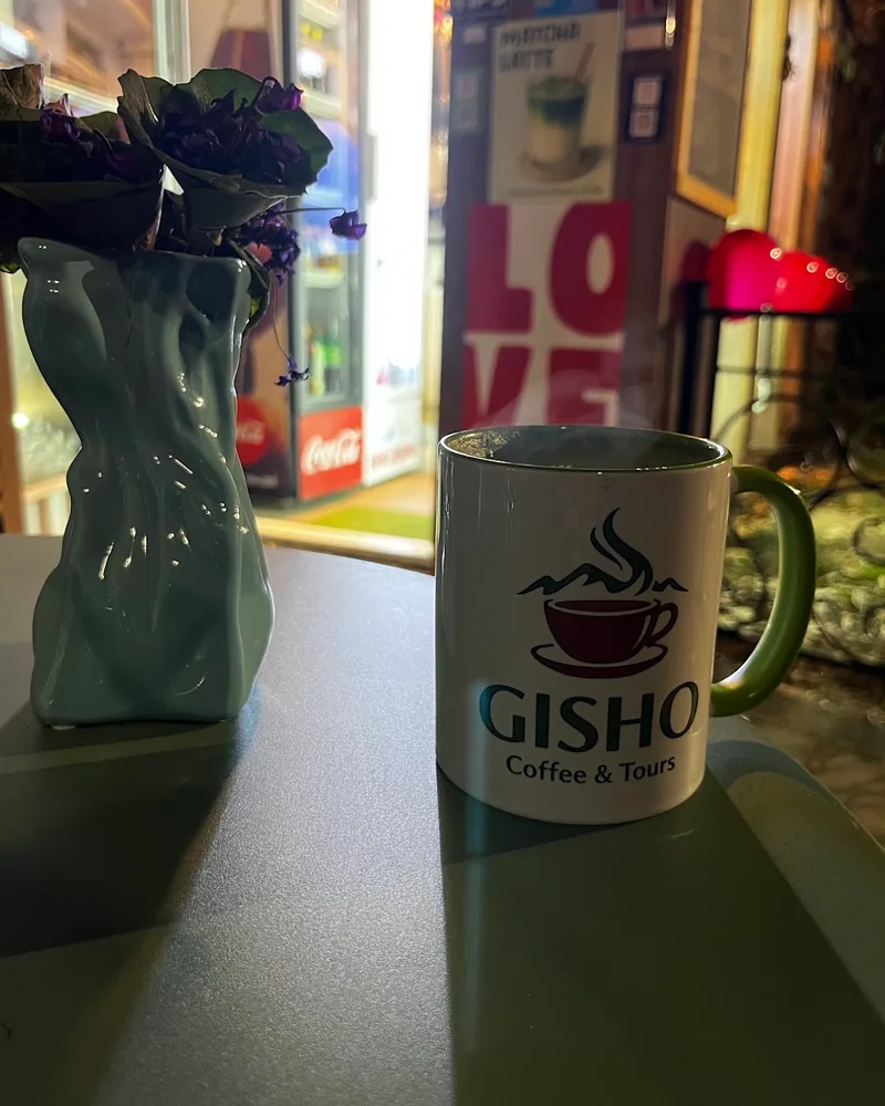 Hot coffee in a branded mug with steam at Gisho Specialty Coffee