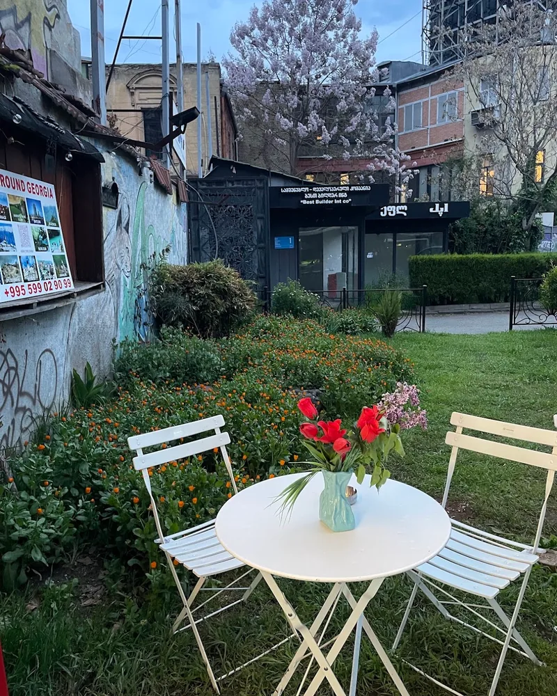 Outdoor garden seating with white bistro table at Gisho Specialty Coffee