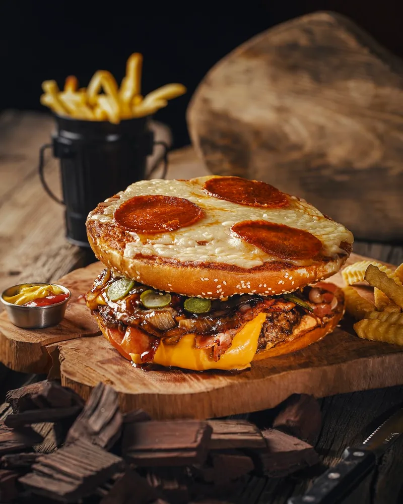 Burger with pepperoni and melted cheese on the bun top at Gochits Burger