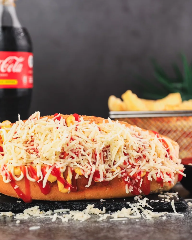 Loaded hot dog with shredded cheese and fries at Good Choice
