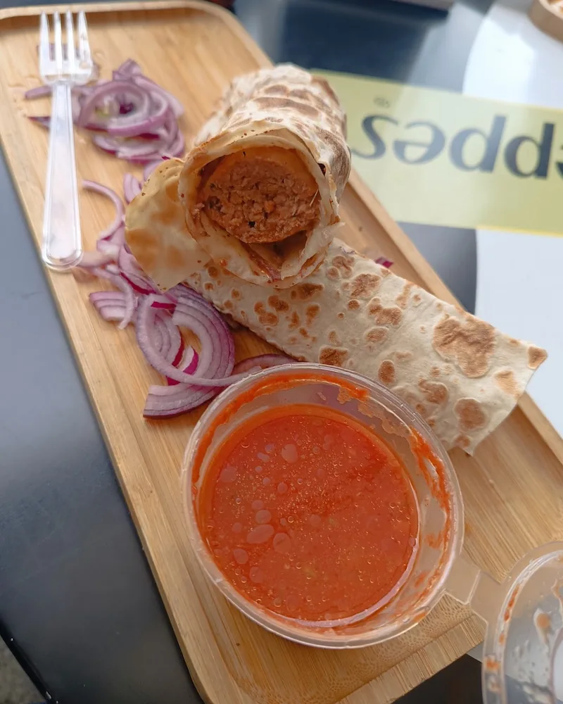 Kebab wrap with sliced red onions and dipping sauce at Green Buffet N1