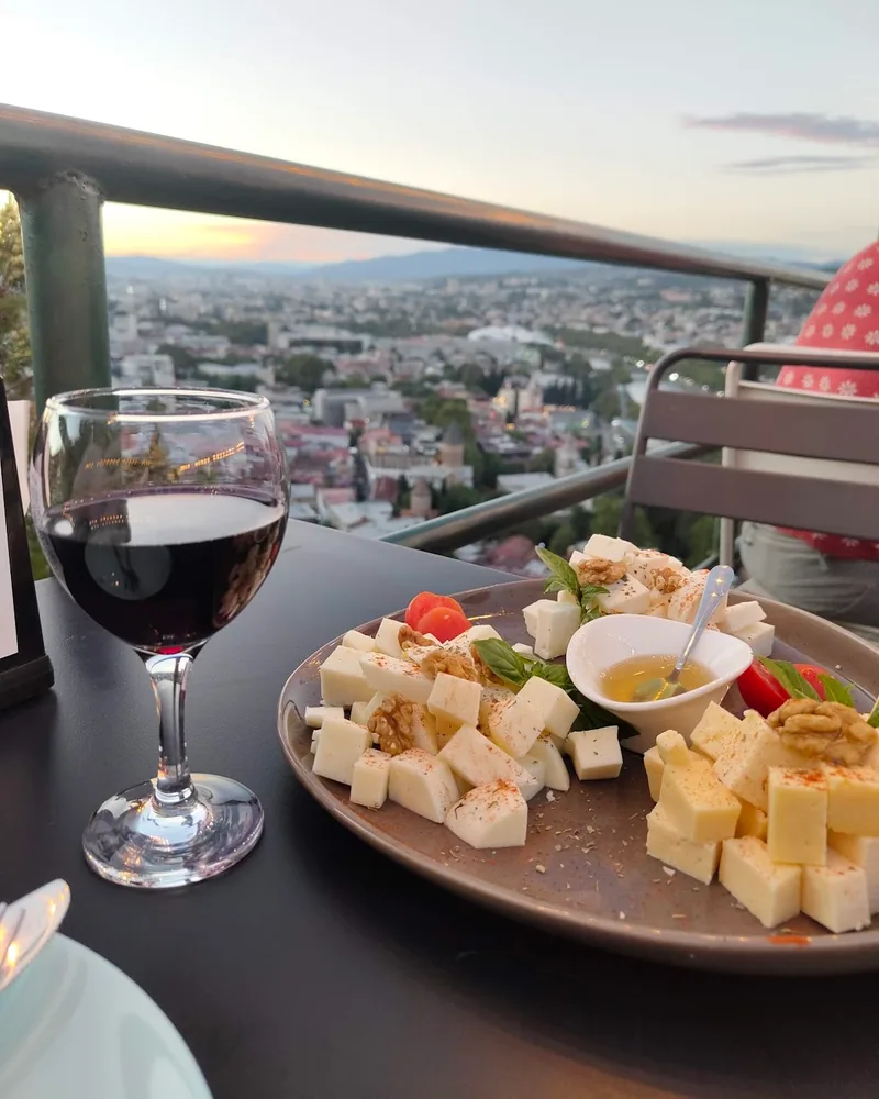 Cheese plate with walnuts and honey alongside red wine at Grilisi City View Bar