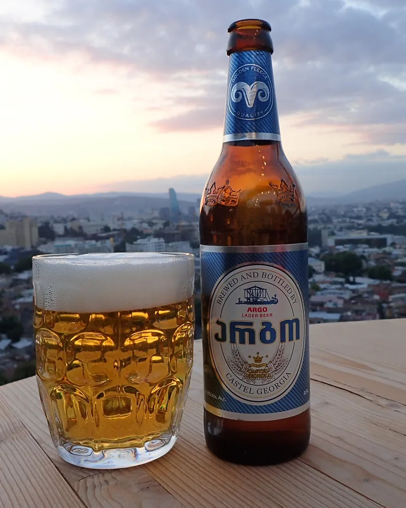 Argo lager beer bottle and glass of beer with city view at Grilisi City View Bar