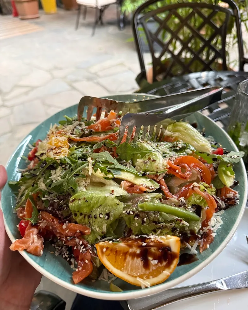 Salmon and greens salad with orange slice at Grill More