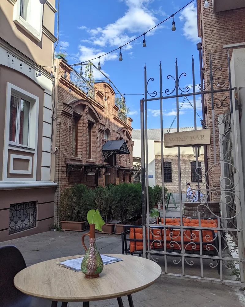 Outdoor courtyard patio behind a decorative iron gate at Gvazi Winery